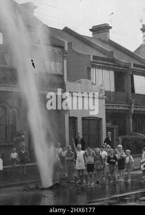 Eine 40 Meter hohe Wassersäule schoss in die Luft, wo heute Morgen eine Wasserleitung in der Telopea-Straße, Redfern, platzte. 12. Januar 1943. (Foto von Barry Newberry/Fairfax Media). ;Eine 40 Meter hohe Wassersäule schoss in die Luft, wo heute Morgen eine Wasserleitung in der Telopea-Straße, Redfern, platzte. Stockfoto