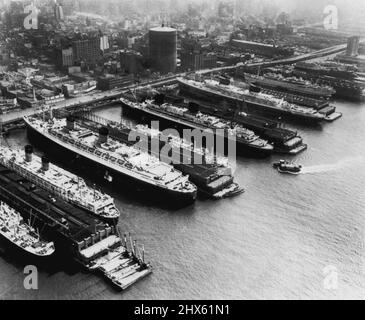 Liners Line Waterfront - hier war ein ungewöhnlicher Anblick entlang des Hudson River, als sieben große Liner, darunter einige der größten der Welt, an ihren Piers festgemacht wurden. Sie sind (von links nach rechts) die Cunard Liner Media, Mauretania, Queen Elizabeth und Georgic, die französische Liner Liberte, die US-amerikanische Liner United States und die italienische Liner Conte Biancamano. Dieser airview wurde aus einem patrouillierten Hubschrauber der Küstenwache hergestellt. 18. Oktober 1952. (Foto von AP Wirephoto).;Liners Line Waterfront - hier war ein un Stockfoto