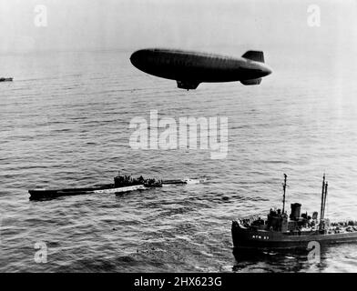 Das Nazi-U-Boot erreicht das Ende der Reise - Ein Luftschiff der US-Marine schwebt über der U-858, dem ersten Nazi-U-Boot, das nach der Kapitulation Deutschlands den amerikanischen Streitkräften aufgab, da es am 14. Mai 1945 einen bestimmten Punkt der Verlegung in atlantischen Küstengewässern erreicht. Das U-Boot hatte sich ursprünglich am 10. Mai einer von zwei Zerstörer-Eskorten der Atlantischen Flotte 300 Meilen (482 km) südlich von Neufundland ergeben. Diese Eskorten, die immer noch das Nazi-Schiff flankierten, lieferten es an einen Punkt vor dem US-Ostküstenstaat New J Stockfoto