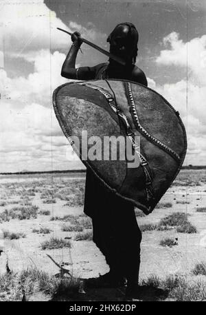 Ein stolzer Krieger aus dem nomadischen Massai-Stamm, der in seiner traditionellen roten Robe gekleidet war und seine alten Waffen trug. Stolzer Masai Krieger posiert mit Speer und Rindsschild. 20. Juni 1955. (Foto von Toni Schuler, PIX Incorporated). ;Ein stolzer Krieger aus dem Nomadenstamm der Masai, gekleidet in seine traditionelle rote Robe und mit seinen alten Waffen. Stolzer Masai Krieger posiert mit Speer und Rindsschild. Stockfoto