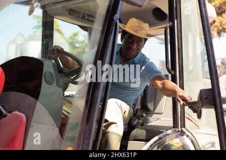 Der Mann, der im Frühjahr den Traktor fährt, arbeitet auf dem Kuhstall Stockfoto