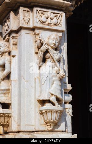 Wandschnitzereien einer weiblichen Figur mit einem Musikinstrument im Hindu Shree Jagat Sheromani Ji Tempel, Udaipur, Indischer Bundesstaat Rajasthan, Indien Stockfoto