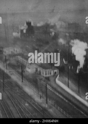 Moskitos Greifen In Le Mans Bei Niedrigem Tageslicht Auf Rangierbahnhöfen Der Eisenbahn An. R.A.F. Bomber Command Moskitos führten am 4./3./43. Einen Tagesangriff auf Reparaturwerkstätten und Rundhäuser auf den Rangierbahnhöfen in Le Mans, Frankreich, durch. Das Aktionsfoto, das während des Low Level Angriffs aufgenommen wurde, zeigt: Bomben, die in der Nähe des Koalingturms südwestlich der Empfangsgleise platzen, und auf Werkstätten zwischen den Rundhäusern. 11. März 1943. (Foto von British Official Photo). Stockfoto