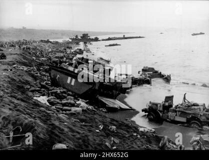 Zu den Ufern von Iwo Jima -- Ampracs und Lastwagen, die von der 'Fighting Fourth' Marine Division benutzt wurden, als sie sich am Nachmittag des D-Day, 19. Februar, in Iwo Jima an Land kämpfte, verwüsten den schwarzen Sand des Strandes. Erste-Hilfe-Stationen (Hintergrund) wurden zwischen den Trümmern von zerstörten und gesprengten Amtraken, Landekahnern, Jeeps und Lastwagen aufgestellt. 6. März 1945. (Foto vom offiziellen US Marine Corps Photo). Stockfoto