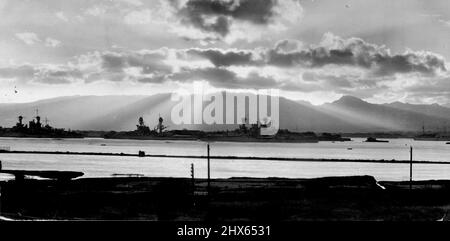 Bezeichnenderweise ergießt sich die aufgehende Sonne durch tropische Wolken auf einige Kampfwagen der US-Pazifikflotte im mächtigen amerikanischen Marinestützpunkt Pearl Harbor in der Nähe von Honolulu. Diese große Binnenbasis verfügt über Ankerplätze für mehr als die 160 Schiffe der Pazifikflotte. Diese Kriegsschiffe stehen für jeden Notfall im westlichen Pazifik bereit. Diese Basis wurde am 31. Mai 1939 zur geheimen Proklamation von Präsident Roosevelt erklärt. 27. Februar 1940. Stockfoto