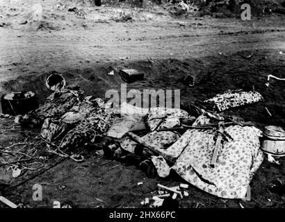 Marine Dead On Iwo Jima -- Eingewickelt in ihre getarnten Ponchos auf dem vulkanischen Sand von Iwo Jima, haben diese galanten Marineinfanteristen ihr Leben in dem blutigen Kampf um die strategische Insel auf dem Weg nach Tokio, Helme, Kraftstoffdosen, Packkisten und Kabelgewirr am Strand in der Nähe der stillen kleinen Gruppe gegeben. Ihre schweren Feldstiefel ragen aus der Decke, die ihre Freunde im Hintergrund* über sie gelegt haben, Amtracks und Panzer rumpeln im Laufe des Kampfes in feindliche Positionen. 23. März 1 Stockfoto