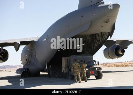 US Air Force Airmen mit 3. Airlift Squadron, 436. Airlift Wing, führen einen Humvee, der 7. Marine Regiment, 1. Marine Division, zugewiesen wurde, auf einen C-17 Globemaster III während einer Kommandopost-Übung im Marine Corps Air Ground Combat Center Twentynine Palms, Kalifornien, 1. März 2022. Diese Entwicklung bot Marines die Gelegenheit, die zweckmäßige Einrichtung eines Regimentshauptquartiers zu üben, um die Kontrolle und Kontrolle von verteilten Standorten aus zu ermöglichen. (USA Marine Corps Foto von Sgt. Jailine L. AliceaSanago) Stockfoto