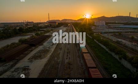 Bahnhof bei Sonnenuntergang, Cargo Container Zug am Abend Import Export benutzerdefinierte Transportkonzept. Stockfoto