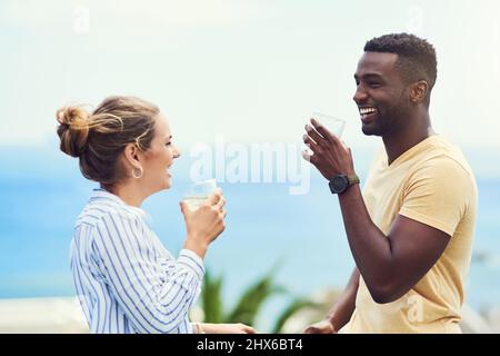 Wir haben diesen Urlaub nach dem letzten Jahr verdient. Aufnahme eines jungen Paares, das zusammen Getränke genießt und sich im Urlaub im Freien entspannt. Stockfoto