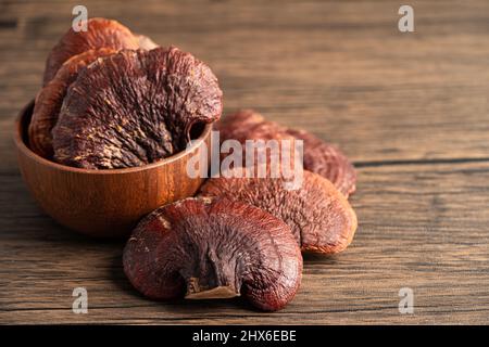 Getrocknete Lingzhi in Schüssel Pilz auf Holz Hintergrund. Stockfoto