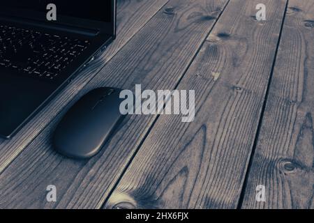 Laptop und Computer Moderne Maus Nahaufnahme auf einer dunklen Holzoberfläche. Stockfoto