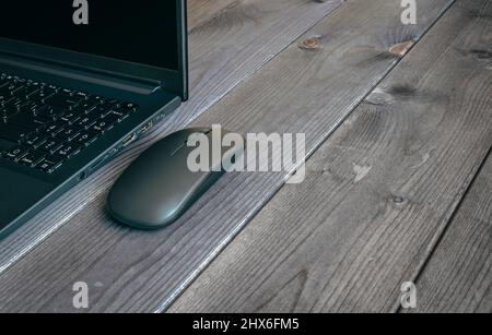 Laptop und Computer Moderne Maus Nahaufnahme auf einer dunklen Holzoberfläche. Stockfoto