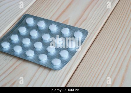 Verpackung von Pillen auf einer hellen Holztischoberfläche. Stockfoto
