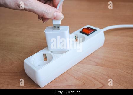 Buchse, die das usb-Kabel mit dem Telefonladegerät einsteckt. Stockfoto