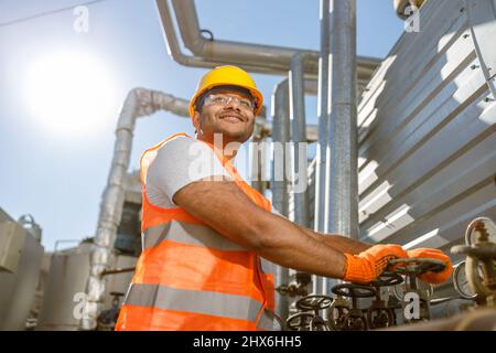 Lächelnder junger Bauingenieur, der im Werk arbeitet Stockfoto