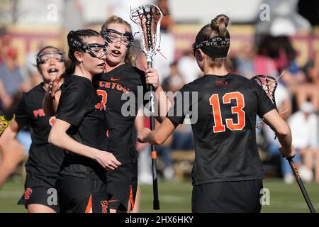 Princeton Tigers Midfeidler Sophie Whiteway (8) feiert mit Mittelfeldspielerin Kari Buonanno (9) und Angreifer Kate Mulham (13) nach einem Tor gegen die Südkalifornien Trojans während eines NCAA College Lacrosse Matches am Dienstag, den 8. März 2022 in Los Angeles. Princeton besiegte den USC mit 18:13. Stockfoto