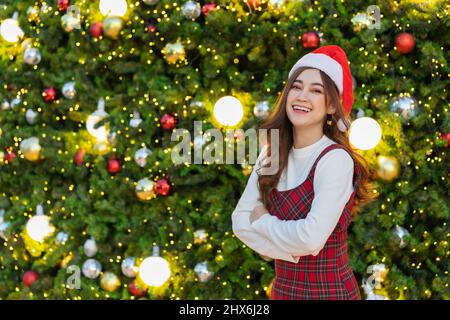 Glückliche Frau in weihnachtsmütze mit Weihnachtsbaum, Weihnachten feiern Stockfoto