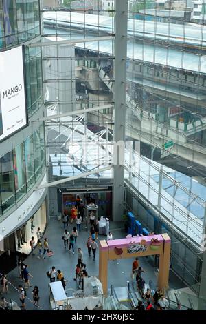 Blick auf das Einkaufszentrum Terminal 21 und die Skywalk-Verbindung zum BTS Skytrain an der Asok Station im Hintergrund Stockfoto