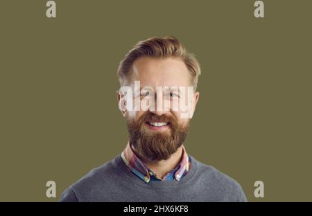 Porträt eines gutaussehenden Mannes mit einem glücklichen Gesichtsausdruck isoliert auf einem grünen Hintergrund Stockfoto