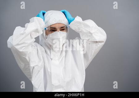 Gestresster Arzt in schützendem PSA-Anzug während einer Coronavirus(covid-19)-Pandemie Stockfoto