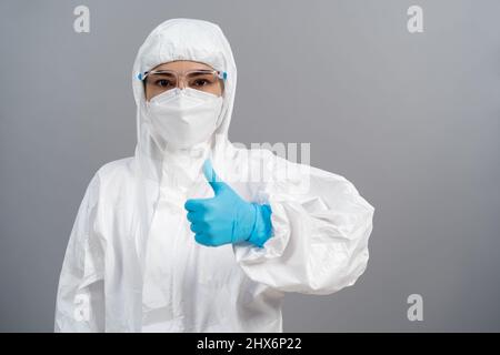 Arzt in Schutzkleidung, der die Hand hochstumpf macht Stockfoto