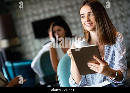 Glückliche Managerin hält Tablet und sitzt im Café Stockfoto