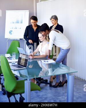 Die Arbeit durch Teamarbeit erledigen. Aufnahme einer Gruppe von Kollegen, die im Sitzungssaal ein Meeting abhalten. Stockfoto