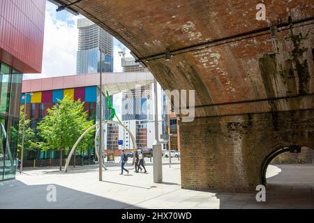 Straßenszene, unter dem Bogen, Manchester City Centre, mit Wolkenkratzer und moderner Architektur Stockfoto