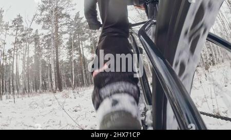 Action Cam am dahinter installierten Rahmen. Nahaufnahme der Pov-Ansicht. Professioneller Extremsportler Biker, der im Winterschneehaus im Freien fette Bikes fährt. Stockfoto