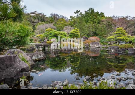 Himeji, Japan - 6. Januar 2020. Außenaufnahme eines japanischen Gartens mit einem Teich mit bunten Fischen in der Nähe des Schlosses Himeji. Himeji Schloss in einem der letzten verbliebenen authentischen Schlösser in Japan und eine beliebte Touristenattraktion. Stockfoto