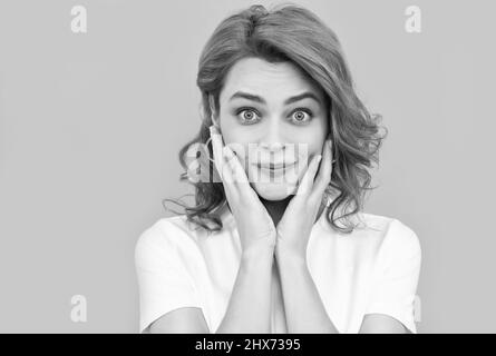 Erstaunt Rotschopf Mädchen mit perfekter Haut und lockiges Haar auf blauem Hintergrund, Porträt der Schönheit Stockfoto