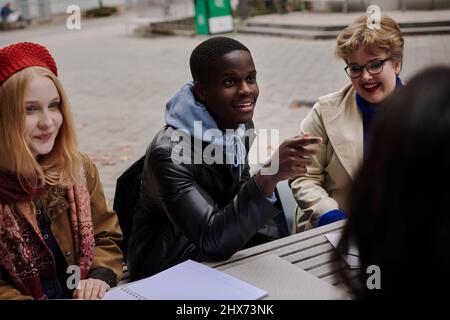 Junge Freunde sitzen zusammen Stockfoto