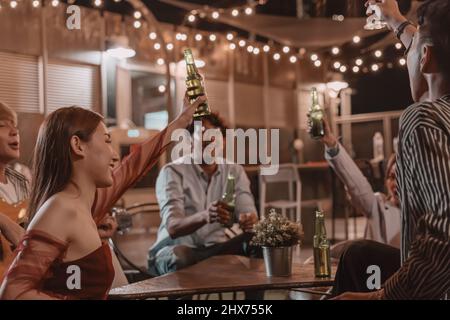 Eine Gruppe junger Freunde, die im Pub und Restaurant essen und Freundschaft feiern Stockfoto