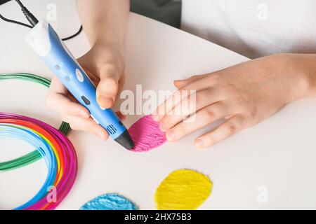 Kind machen Ostereier durch 3D Stift Kunststoff-Filamente auf weißem Hintergrund. Nahaufnahme. Stockfoto
