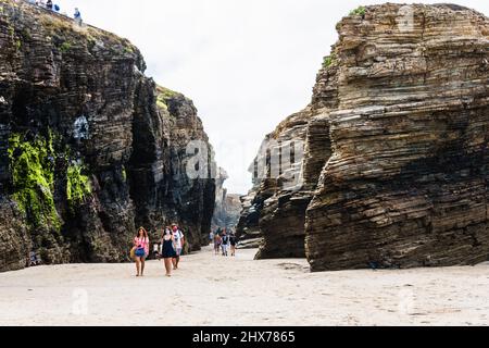 Ribadeo, Lugo, Galicien, Spanien - 26. Juli 2020: Touristen, die bei Ebbe am Playa de las Catedrales entlang gehen, erklärten Aguas Santas zu einem Naturmonume Stockfoto