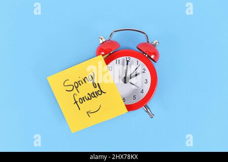 Konzept für Sommerzeitumstellung mit Uhr und Notiz „Spring Forward“ Stockfoto