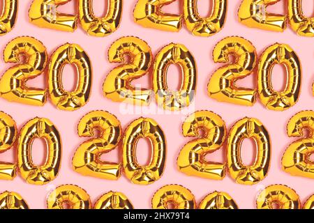 Zahlen 20 goldene Luftballons Muster. Konzept zur Feier des 20-jährigen Bestehens auf einem rosa Hintergrund. Stockfoto