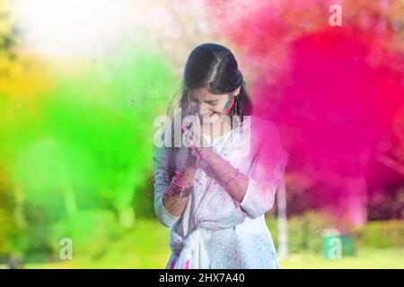 Ein indisches Mädchen, das Holi mit Puderfarben oder Gulal feiert. Stockfoto