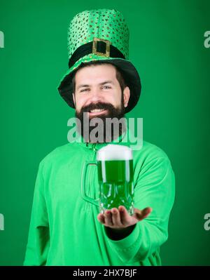 Frisch gezapftes Bier. Hipster in grünen Kobold hat Holding Bierkrug. Irische Mann mit Bart trinken grünen Bier. Feiern Saint Patricks Day in bar Stockfoto