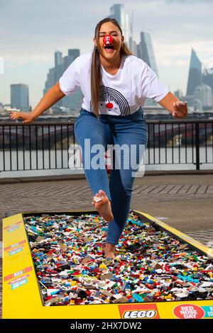 REDAKTIONELLE VERWENDUNG NUR die Schauspielerin Jacqueline Jossa geht barfuß über einen Backsteinpfad aus 30.000 LEGO Steinen am Observation Point in London, um Geld für den Red Nose Day 2022 von Comic Relief zu sammeln. Bilddatum: Donnerstag, 10. März 2022. Stockfoto