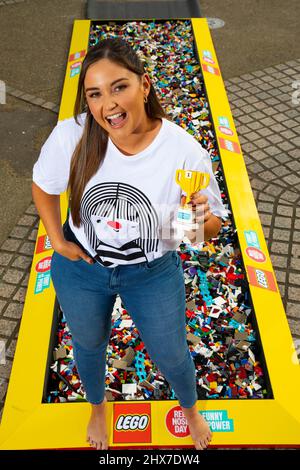 REDAKTIONELLE VERWENDUNG NUR die Schauspielerin Jacqueline Jossa geht barfuß über einen Backsteinpfad aus 30.000 LEGO Steinen am Observation Point in London, um Geld für den Red Nose Day 2022 von Comic Relief zu sammeln. Bilddatum: Donnerstag, 10. März 2022. Stockfoto