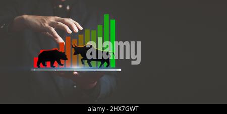 Investitionshintergrund, Zeichnung eines Bullen und eines Bären auf der Hand eines Marktmachers auf einem Candlestick-Chart, Wall Street Spekulation Konzept, Markttren Stockfoto