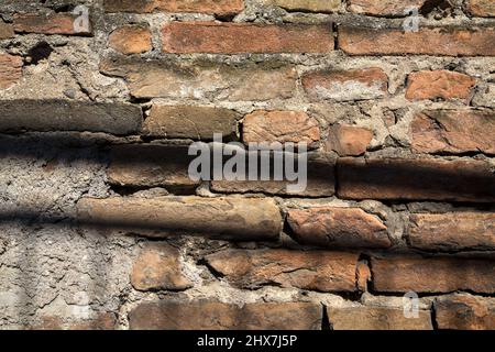 Ziegelwand mit Schatten, die darauf gegossen wurden Stockfoto