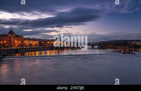 Verträumte Nacht Blick auf die Moldau mit magischem Himmel und Lichter von den Straßen am frühen Morgen von der Karlsbrücke in der Altstadt von Prag. Stockfoto