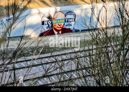 Danzig, Polen. 10. März 2022. Ein Wandgemälde von Putin, Hitler und Stalin mit dem Slogan „No More Time“ ist an der Wand neben dem Bahnhof Danzig-Jasien der PKM zu sehen. Die erste einer Serie von Wandgemälden gegen den Krieg mit dem Titel „Solidarität mit der Ukraine“ wurde erstellt. Der Autor ist Tuse, einer der bekanntesten Straßenkünstler in Polen. Es ist eine gemeinsame Initiative der Woiwodschaft Pommern, der Pommerschen Stadtbahn und der Akademie der Schönen Künste in Danzig. Kredit: SOPA Images Limited/Alamy Live Nachrichten Stockfoto