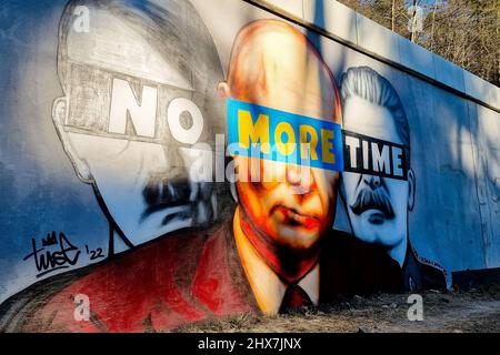 Danzig, Polen. 10. März 2022. Ein Wandgemälde von Putin, Hitler und Stalin mit dem Slogan „No More Time“ ist an der Wand neben dem Bahnhof Danzig-Jasien der PKM zu sehen. Die erste einer Serie von Wandgemälden gegen den Krieg mit dem Titel „Solidarität mit der Ukraine“ wurde erstellt. Der Autor ist Tuse, einer der bekanntesten Straßenkünstler in Polen. Es ist eine gemeinsame Initiative der Woiwodschaft Pommern, der Pommerschen Stadtbahn und der Akademie der Schönen Künste in Danzig. Kredit: SOPA Images Limited/Alamy Live Nachrichten Stockfoto