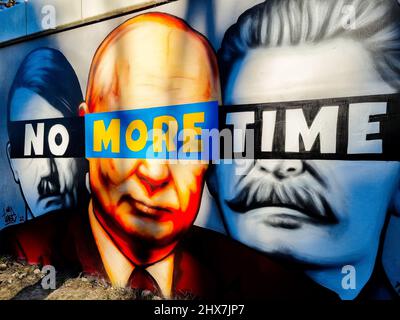 Danzig, Polen. 10. März 2022. Ein Wandgemälde von Putin, Hitler und Stalin mit dem Slogan „No More Time“ ist an der Wand neben dem Bahnhof Danzig-Jasien der PKM zu sehen. Die erste einer Serie von Wandgemälden gegen den Krieg mit dem Titel „Solidarität mit der Ukraine“ wurde erstellt. Der Autor ist Tuse, einer der bekanntesten Straßenkünstler in Polen. Es ist eine gemeinsame Initiative der Woiwodschaft Pommern, der Pommerschen Stadtbahn und der Akademie der Schönen Künste in Danzig. Kredit: SOPA Images Limited/Alamy Live Nachrichten Stockfoto