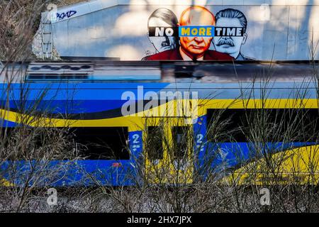 Danzig, Polen. 10. März 2022. Ein Wandgemälde von Putin, Hitler und Stalin mit dem Slogan „No More Time“ ist an der Wand neben dem Bahnhof Danzig-Jasien der PKM zu sehen. Die erste einer Serie von Wandgemälden gegen den Krieg mit dem Titel „Solidarität mit der Ukraine“ wurde erstellt. Der Autor ist Tuse, einer der bekanntesten Straßenkünstler in Polen. Es ist eine gemeinsame Initiative der Woiwodschaft Pommern, der Pommerschen Stadtbahn und der Akademie der Schönen Künste in Danzig. Kredit: SOPA Images Limited/Alamy Live Nachrichten Stockfoto