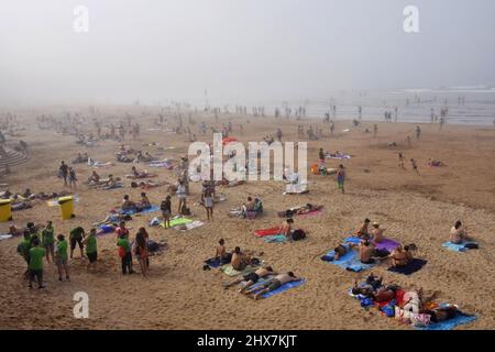 Menschen Urlauber am Strand Playa de San Lorenzo. Nebliger Sommernachmittag in Gijon Asturias Spanien. Stockfoto