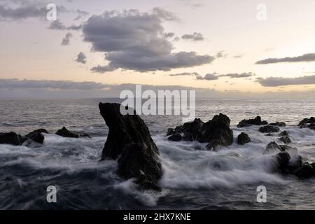 Vulkanisches Gestein an der Atlantikküste in der Abenddämmerung in Funchal Madeira Portugal. Stockfoto